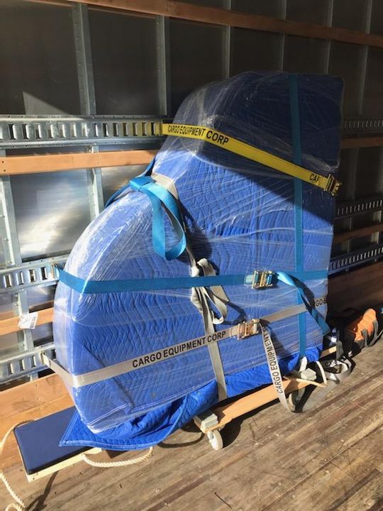Piano wrapped in moving pads and strapped for transport (Piano) by Moving Pros CLE