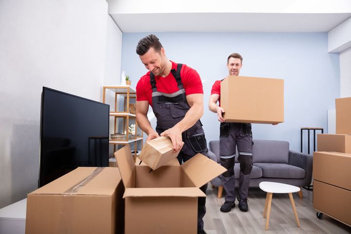 Movers unpacking boxes in a living room (Unpacking Services) by Moving Pros CLE